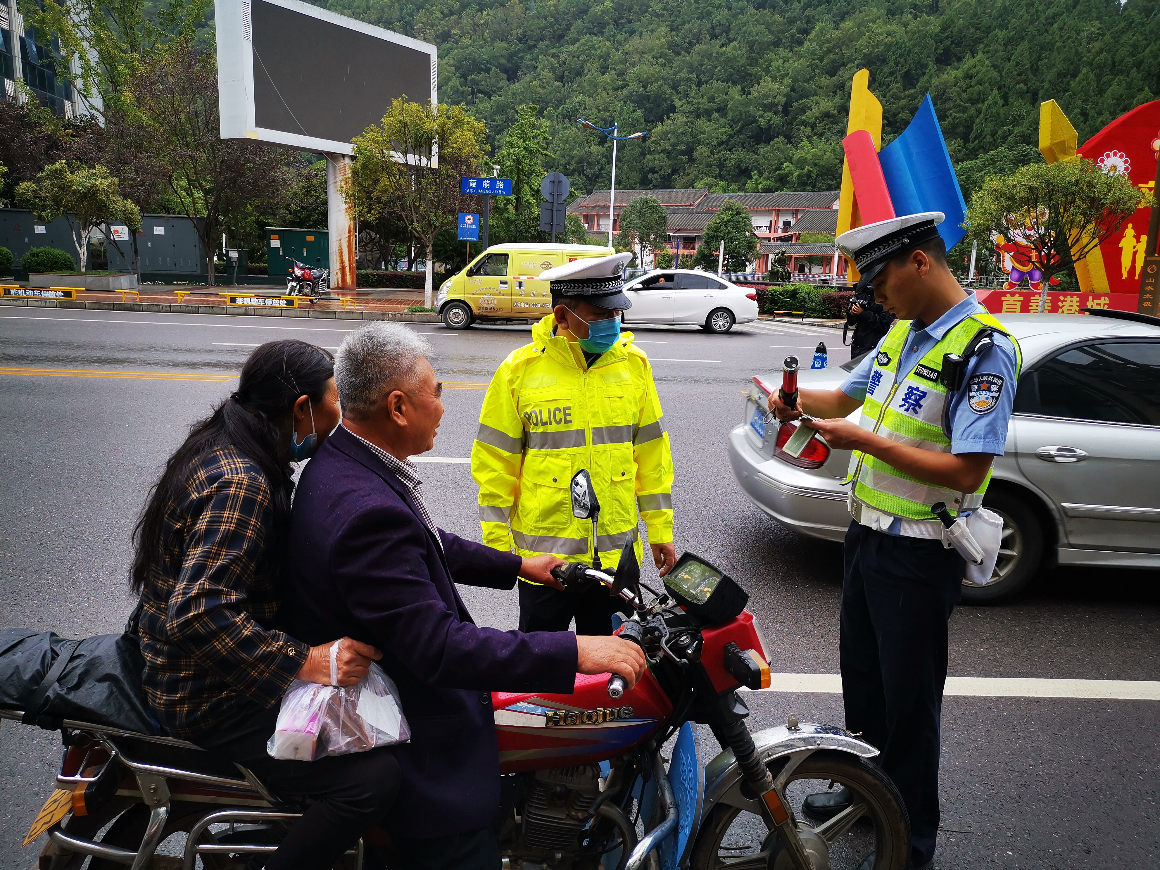 民警查处摩托车驾乘人员不戴头盔违法.jpg